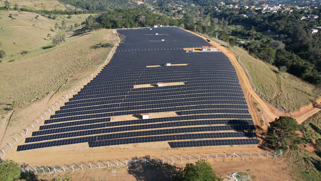 Fileiras de módulos solares com a cidade ao fundo